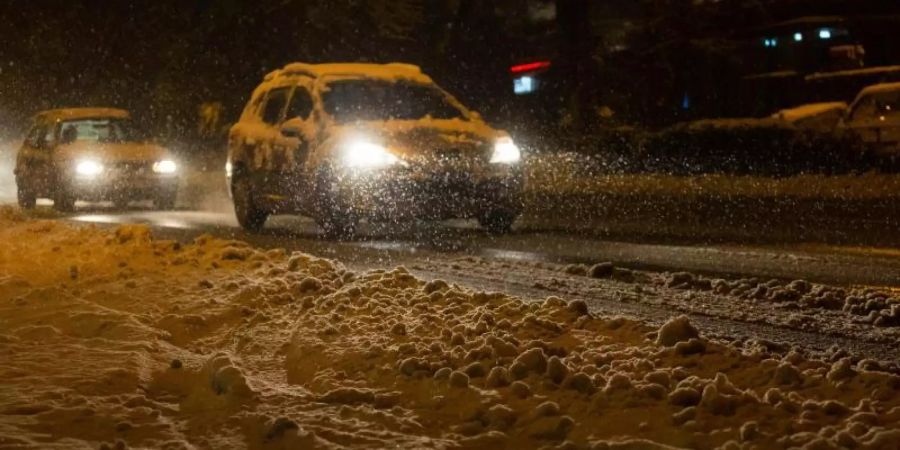 Autos sind in Freiburg im dichten Schneetreiben unterwegs. Foto: Philipp von Ditfurth/dpa