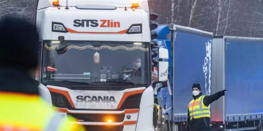 Polizisten kontrollieren auf einem Parkplatz kurz nach der deutsch-tschechischen Grenze Fahrzeuge. Foto: Armin Weigel/dpa