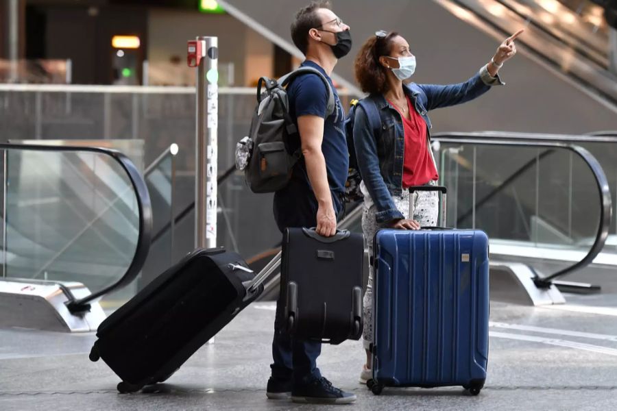 Reisende suchen am Flughafen Zürich das Gate für ihren Flug.