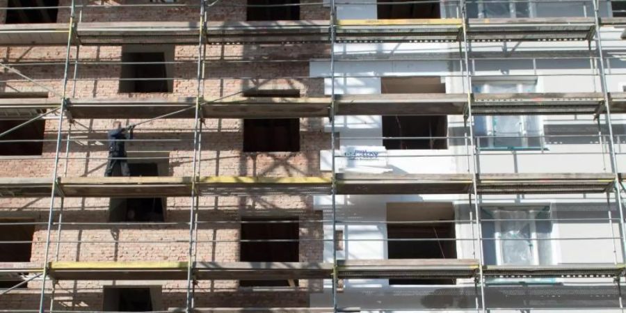 An einem Altbau wird während der Renovierung eine Wärmedämmung an die Fassade angebracht. Foto: Arno Burgi/dpa-Zentralbild/dpa