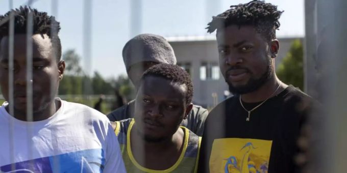 Migranten aus Kamerun stehen am Zaun eines Flüchtlingslagers in Litauen. Foto: Mindaugas Kulbis/AP/dpa Migranten aus Kamerun stehen am Zaun eines Flüchtlingslagers in Litauen. Foto: Mindaugas Kulbis/AP/dpa