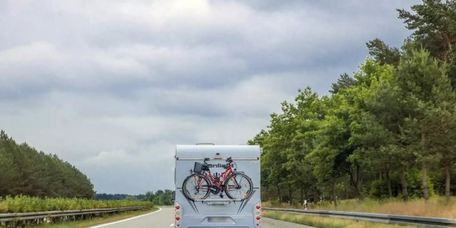 Ein Wohnmobil mit Fahrrädern am Heck auf der Autobahn A24. Als erstes der Bundesländer startet Mecklenburg-Vorpommern in die grossen Ferien. Foto: Jens Büttner/dpa-Zentralbild/dpa