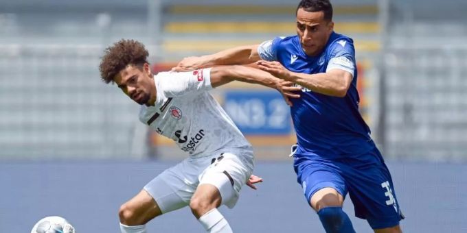 Luis Coordes (l) vom FC St. Pauli schirmt den Ball gegen Änis Ben-Hatira ab. Foto: Matthias Hangst/Getty Images Europe/Pool/dpa Luis Coordes (l) vom FC St. Pauli schirmt den Ball gegen Änis Ben-Hatira ab. Foto: Matthias Hangst/Getty Images Europe/Pool/dpa
