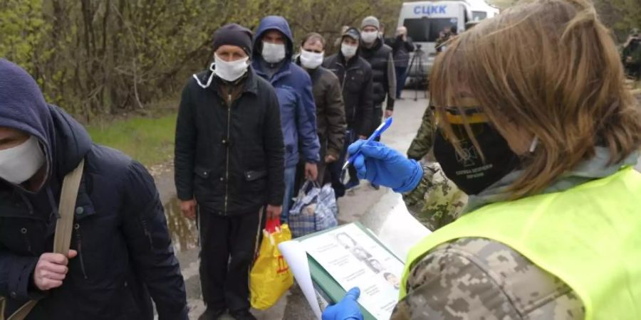 Gefangene mit Mundschutz werden registriert. Foto: Uncredited/Ukrainian Presidential Press Off/AP/dpa