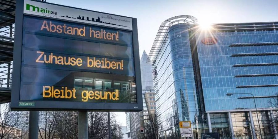 Ein Schild in Frankfurt/Main: "Abstand halten! Zuhause bleiben! Bleibt gesund!". Foto: Frank Rumpenhorst/dpa