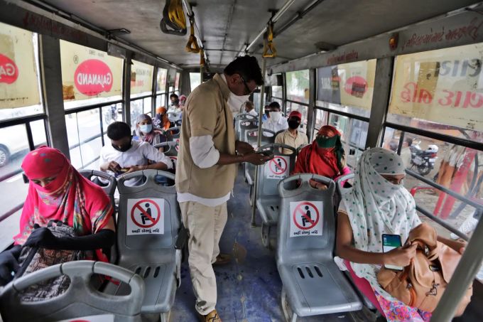 Menschen sitzen in einem Stadtbus in einem indischen Land. In Indien können die Menschen nach gut zweieinhalb Monaten Pause seit Montag wieder in Restaurants essen, in Gotteshäusern beten, in Shoppingzentren einkaufen und in ihren Büros arbeiten. Coronavirus - Indien