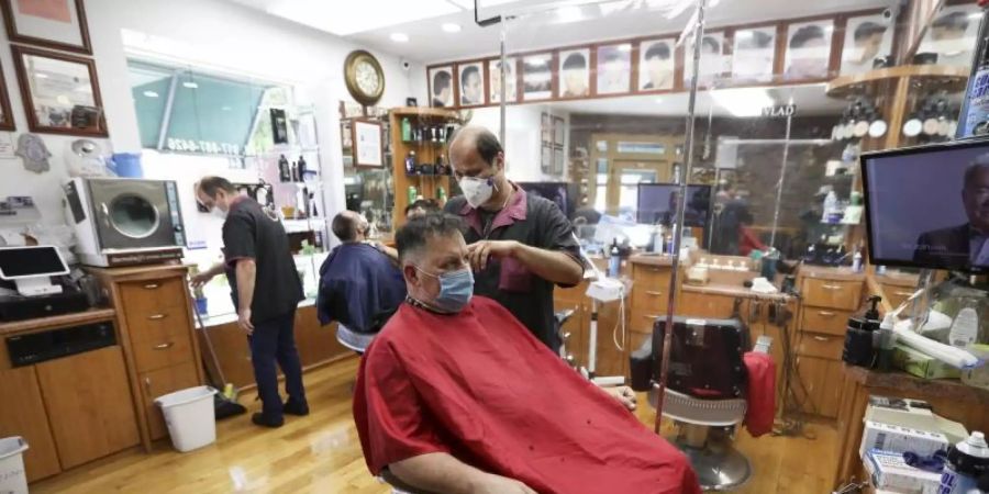 Kunden sitzen in einem New Yorker Friseurladen. Foto: Wang Ying/XinHua/dpa