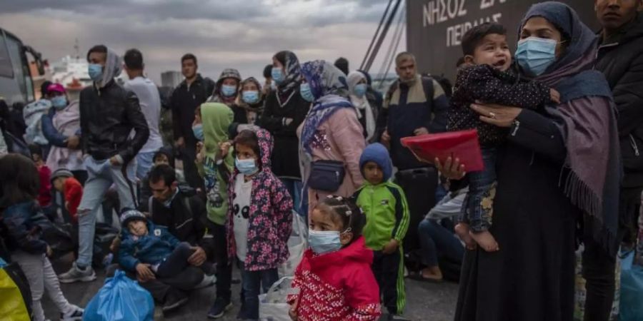 Flüchtlinge aus dem Lager Moria auf Lesbos gehen im Hafen von Piräus bei Athen an Land. Die Asylreform kommt seit Jahren kaum voran, weil die EU-Staaten vor allem bei der Verteilung von Schutzsuchenden völlig zerstritten sind. Foto: Angelos Tzortzinis/dpa/dpa