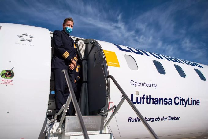 Lufthansa Flugkapitän Götz Herchenbach steht am Flughafen Münster-Osnabrück an der Tür einer Lufthansa CityLine Maschine. Foto: Guido Kirchner Flughafen Münster-Osnabrück