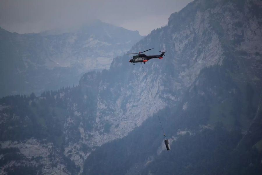 Der Heliswiss Super Puma fliegt am 08.07.19 mit einem Mastenteil zu den Fundamenten.