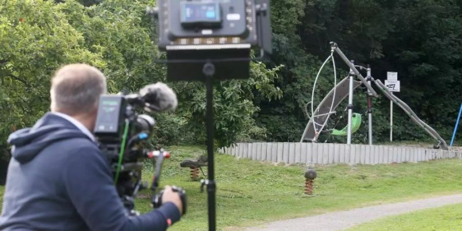 Ein Kameramann filmt den Spielplatz, in dessen Nähe eine junge Frau von einer Gruppe Jugendlicher überfallen und sexuell missbraucht wurde. Foto: Roland Weihrauch