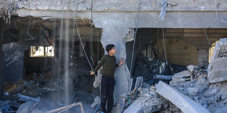 dpatopbilder - Ein Kind steht zwischen zerstörten Gebäuden nach einem israelischen Angriff. Foto: Mohammed Talatene/dpa