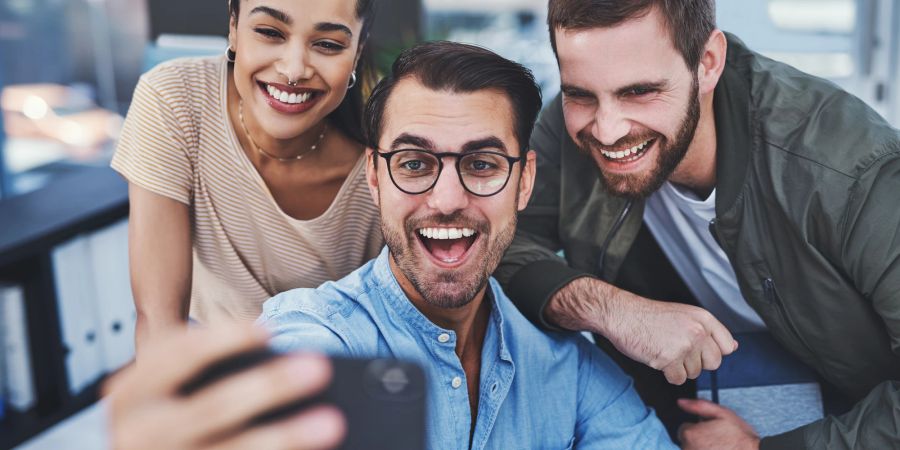 Zwei Männer und eine Frau machen Selfie