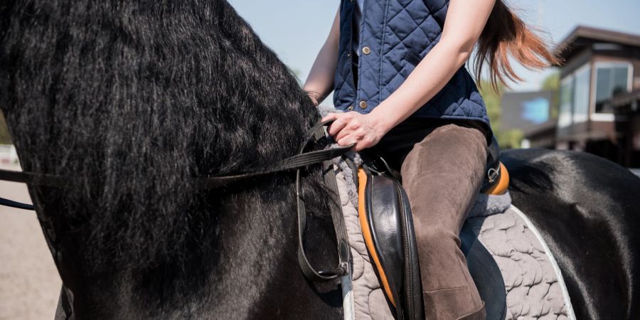 Frau sitzt auf Pferd