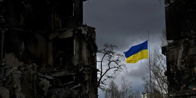 Ukrainische Flagge zwischen Ruinen