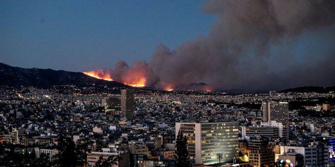Rauch steigt hinter einem Berg nördlich von Athen auf. Nahe der griechischen Hauptstadt wird ein grosser Waldbrand von starkem Wind angefacht - deshalb sind Hunderte Menschen angehalten, ihre Häuser zu verlassen. Panagiotis Moschandreou/XinHua/dpa Klima