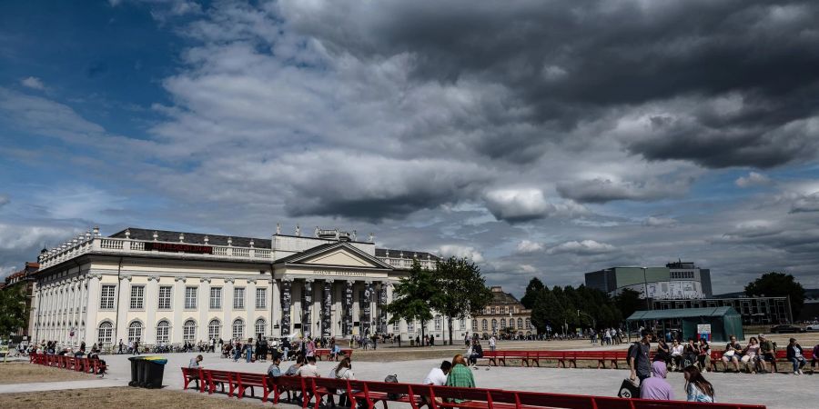Besucher der documenta fifteen gehen am Museum Fridericianum vorbei.