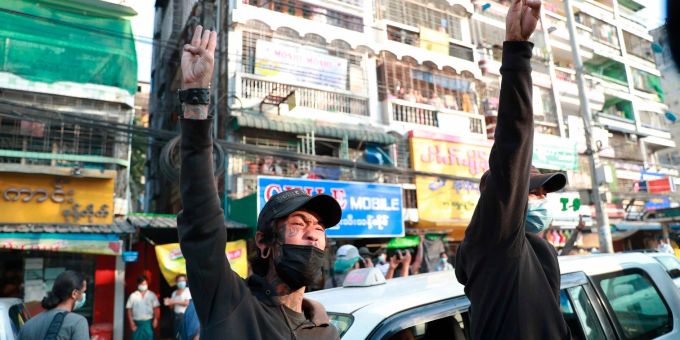 Zwei Männer erheben im Februar 2021 die Hände zu einem Drei-Finger-Gruss - ein Zeichen des Widerstandes gegen den Militärputsch. Zwei Männer erheben im Februar 2021 die Hände zu einem Drei-Finger-Gruss - ein Zeichen des Widerstandes gegen den Militärputsch.