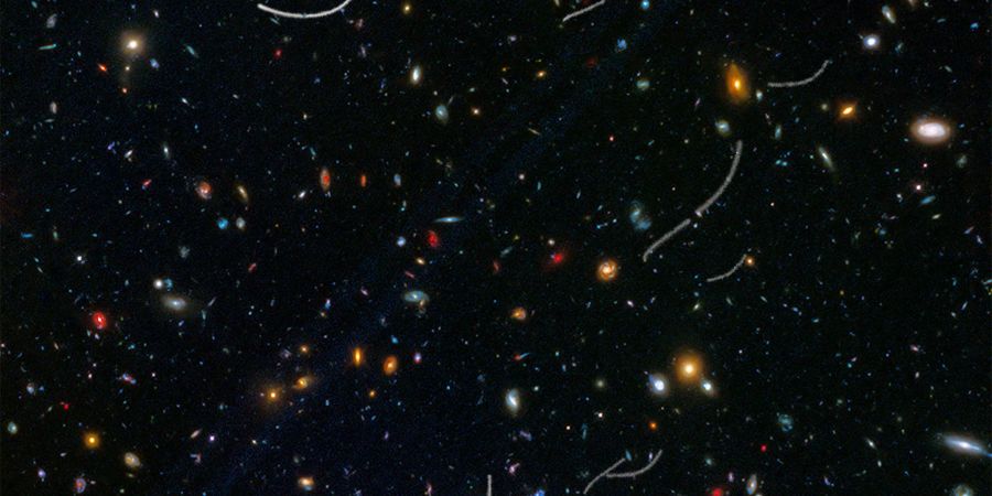 Für das Bild wurden Aufnahmen des Weltraumteleskops Hubble übereinander gelegt. Es zeigt die Bahnen mehrerer Asteroiden (weisse Linien).