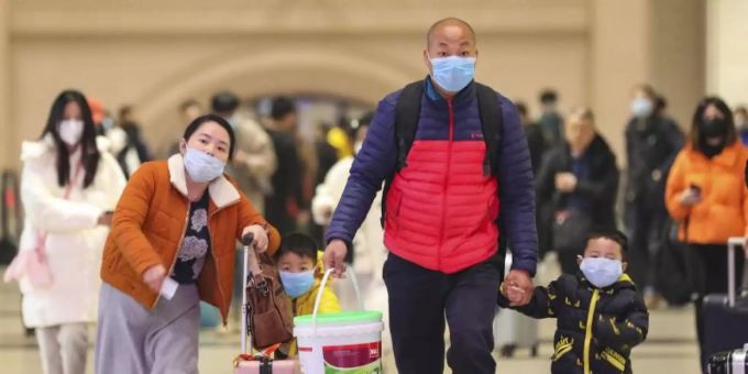 Reisende mit Atemschutzmasken gehen durch den Bahnhof Hankou in der chinesischen Stadt Wuhan. coronavirus