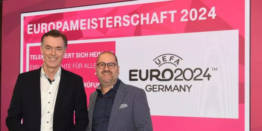 Die EM 2024 wird in Deutschland von der Telekom übertragen: Michael Hagspihl (l) von der Telekom und Michael Schuld, Chef des Streaming-Anbieters Magenta TV. Foto: Felix Hörhager/dpa