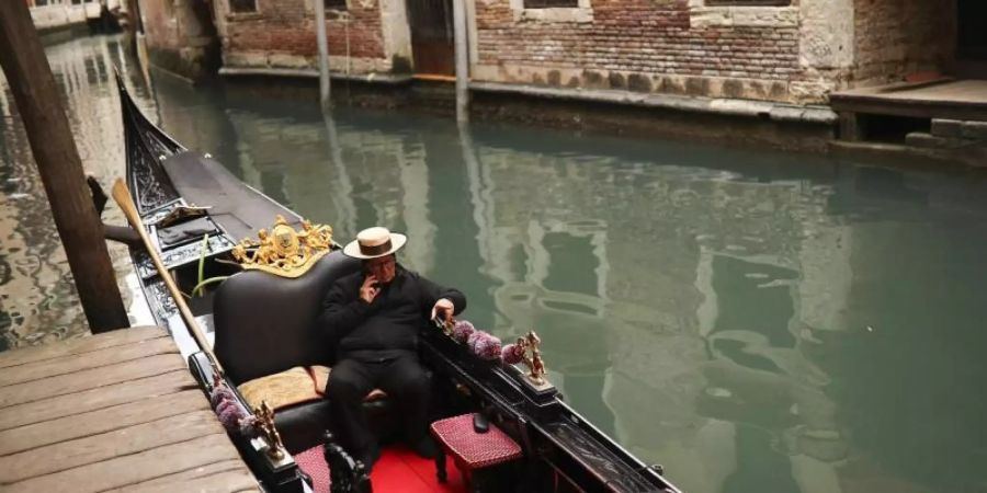 Ein einsamer Gondoliere wartet in Venedig auf Kunden. Der Ausbruch des Coronavirus beeinträchtig den Tourismus in Italien. Foto: Francisco Seco/AP/dpa