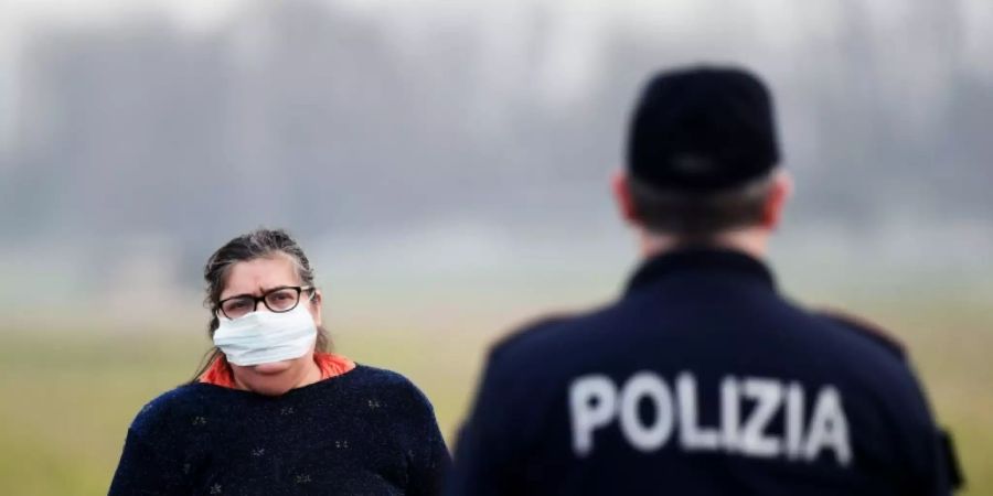 Eine Bewohnerin der Kleinstadt Casalpusterlengo spricht mit einem Polizisten