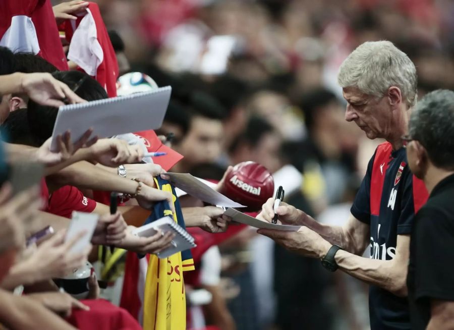 Arsène Wenger gibt Autogramme.