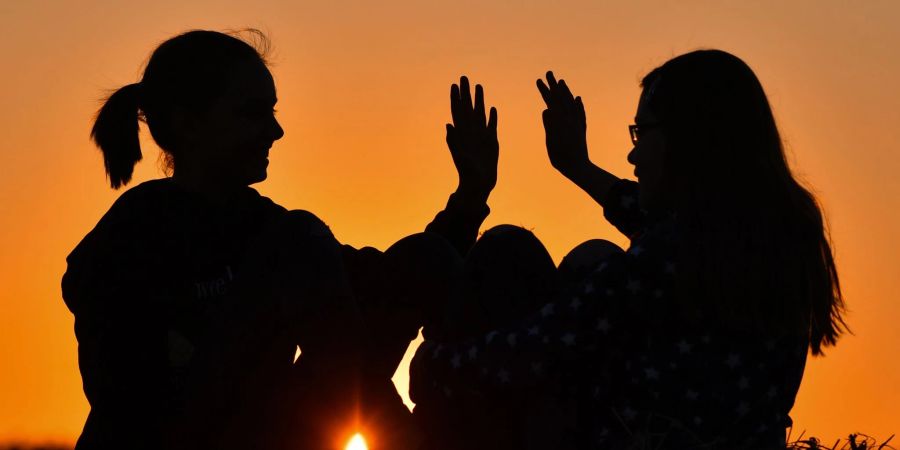 Zwei Freundinnen klatschen sich einvernehmlich ab, laut einer Umfrage sind viele junge Menschen optimistisch, was ihre eigene Zukunft angeht.