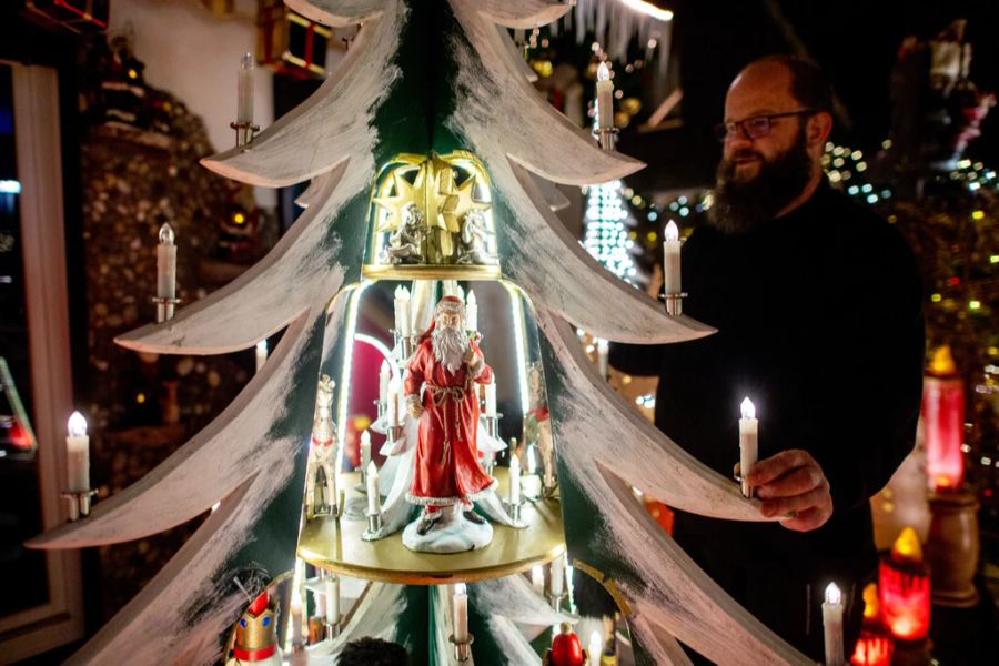 Sven Borchart aus Delmenhorst (Niedersachsen) schmückt seinen Garten mit Weihnachtslichtern.