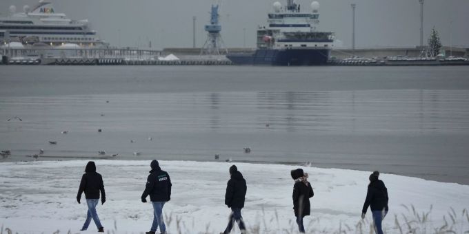 Menschen gehen nach einem Schneefall in Tallinn, Estland, am Sonntag, 11. Dezember 2022, am Meer entlang. Estonia Weather