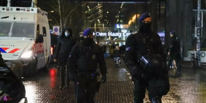 Niederländische Polizisten patrouillieren vor einem Ministeriumsgebäude. Foto: Peter Dejong/AP/dpa lockdown