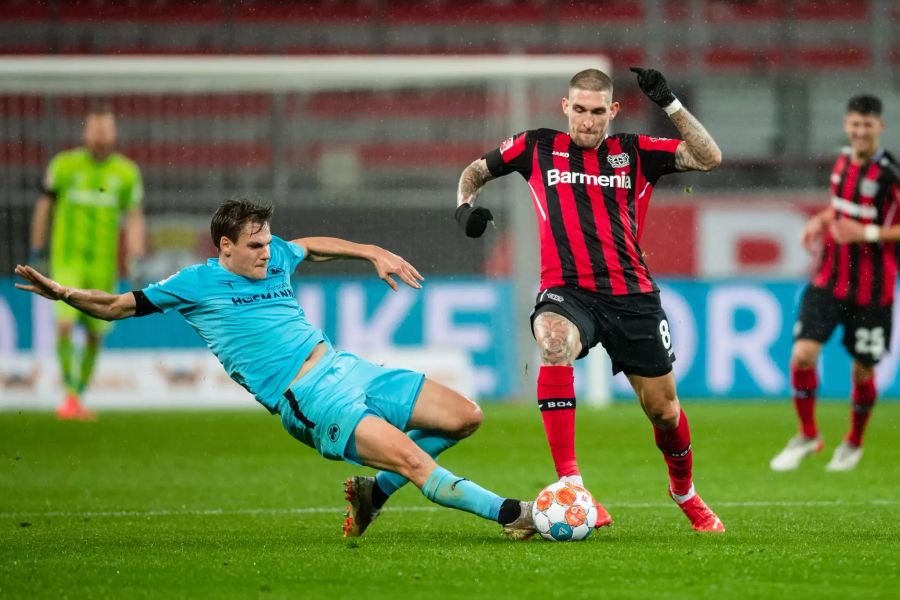 Fürth-Verteidiger Max Christiansen (l.) grätscht gegen Leverkusens Robert Andrich (r.).