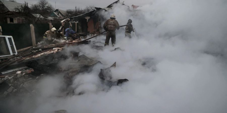 Feuerwehrleute löschen ein Feuer nach Beschuss im ukrainischen Charzysk.