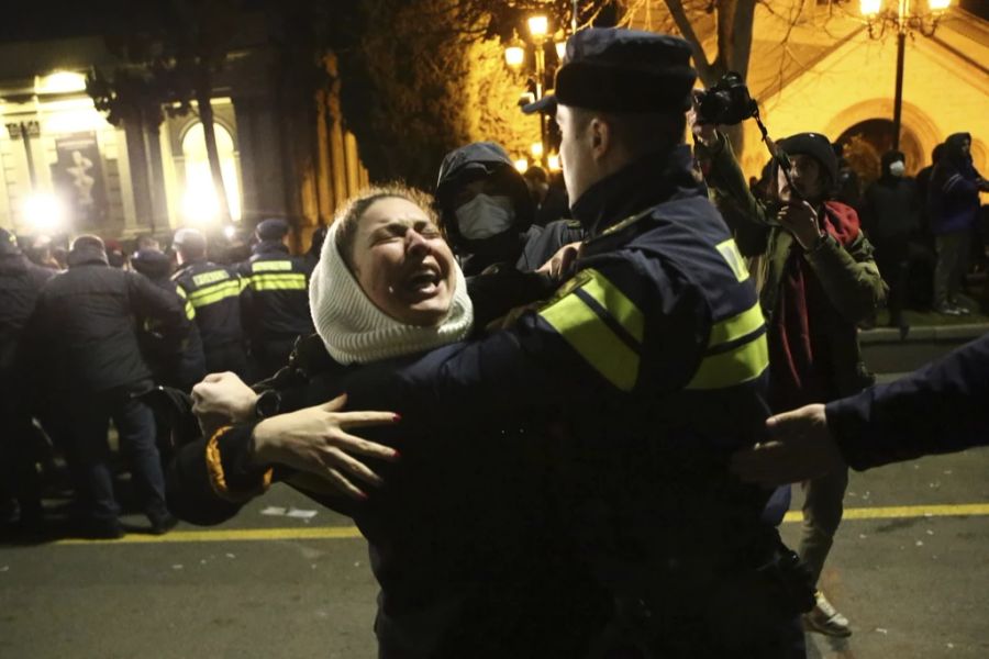 Ein georgischer Polizist hält einen Demonstranten während einer Demonstration vor dem georgischen Parlamentsgebäude in Tiflis, Georgien, Mittwoch, 8. März 2023, fest. Die georgischen Behörden setzten am Dienstag Tränengas und Wasserwerfer vor dem Parlamentsgebäude in der Hauptstadt gegen Demonstranten ein, die sich gegen ein vorgeschlagenes Gesetz wehrten, das einige als Einschränkung der Pressefreiheit ansehen.