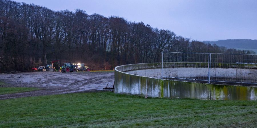 Ein Landwirt mit Helfern versucht die Gülle von seinem Feld zu beseitigen, die aus einem defekten Tank ausgelaufen war.