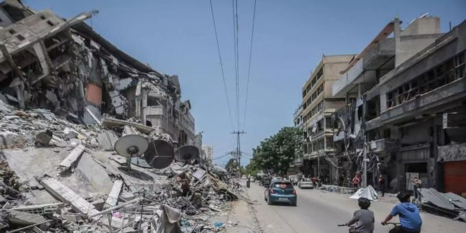 Palästinenser fahren an Gebäuden in Gaza vorbei, die durch israelische Luftangriffe zerstört wurden. Foto: Mohammed Talatene/dpa waffenruhe