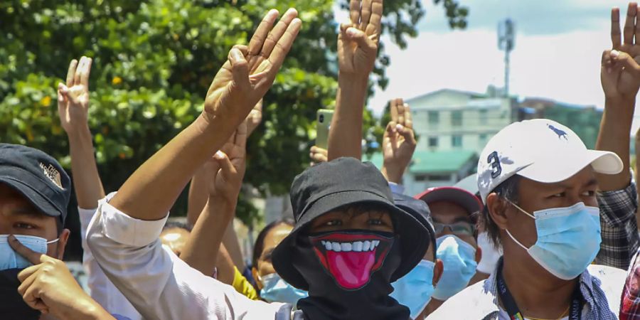 Demonstranten zeigen den Drei-Finger-Gruss, zum Zeichen des Widerstands, bei einer Protestaktion gegen den Militärputsch in Myanmar. Foto: Uncredited/AP/dpa