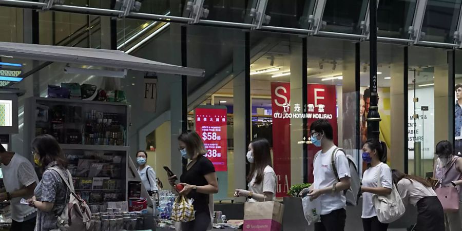 Menschen stehen an einem Zeitungsstand Schlange, um Exemplare der Zeitung Apple Daily zu kaufen. Foto: Vincent Yu/AP/dpa