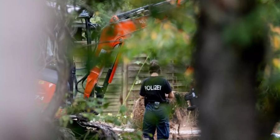 Polizeibeamte durchsuchen eine Kleingarten-Parzelle am Stadtrand von Hannover. Foto: Peter Steffen/dpa