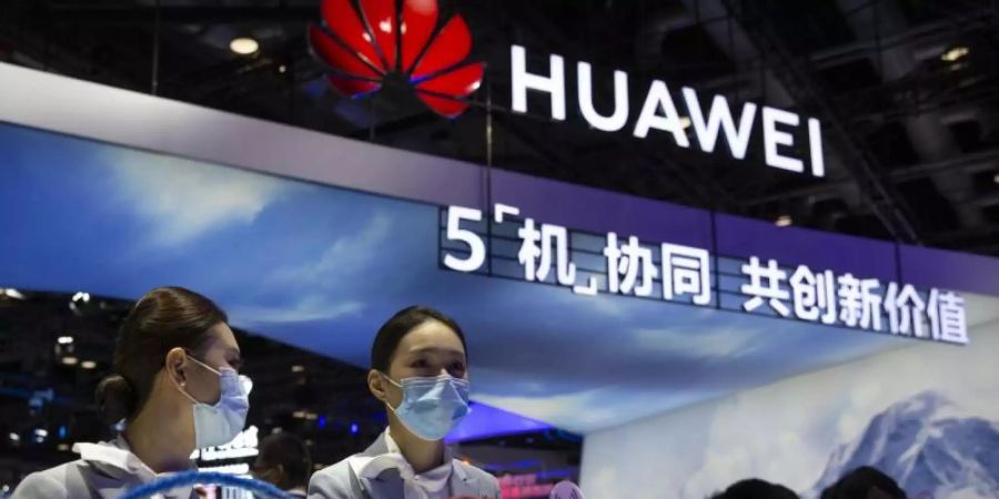 Mitarbeiter stehen an einem Stand des chinesischen Technologieunternehmens Huawei auf der PT Expo in Peking. Foto: Mark Schiefelbein/AP/dpa