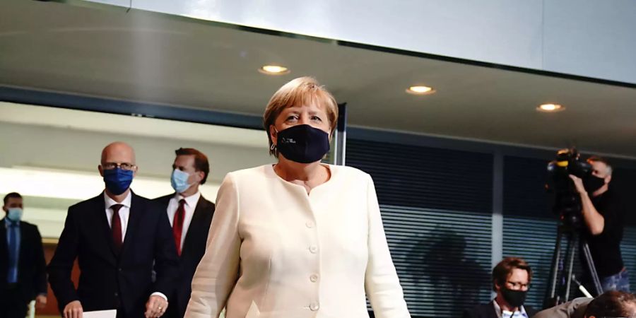 Bundeskanzlerin Angela Merkel (CDU) und Peter Tschentscher (SPD -2.v.l.), Erster Bürgermeister von Hamburg, kommen zur Pressekonferenz. Foto: Kay Nietfeld/dpa