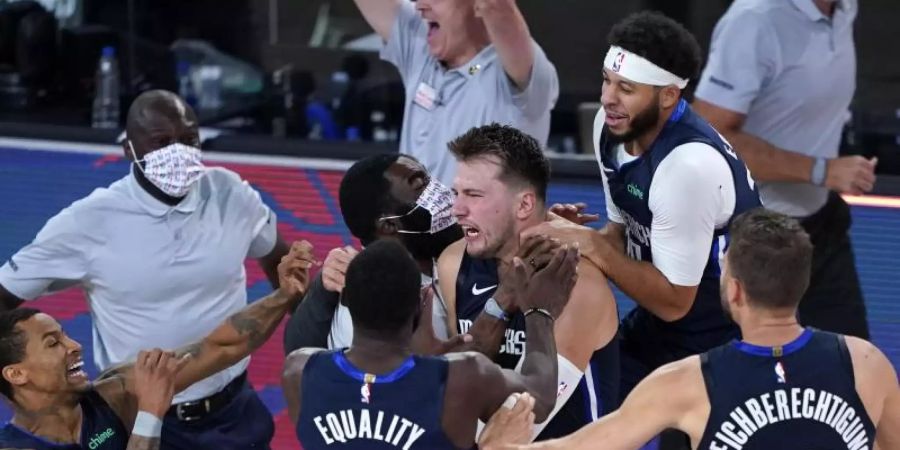 Luka Doncic (M) von den Dallas Mavericks feiert mit seinen Teamkollegen. Foto: Ashley Landis/Pool AP/dpa