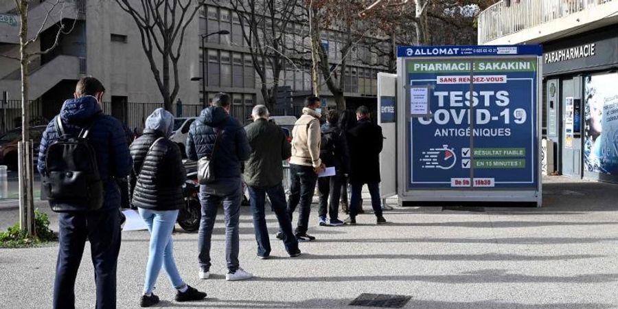 Menschen stehen vor einer Apotheke in Marseille an, um einen Corona-Schnelltest zu erhalten. Foto: Nicolas Tucat/AFP/dpa