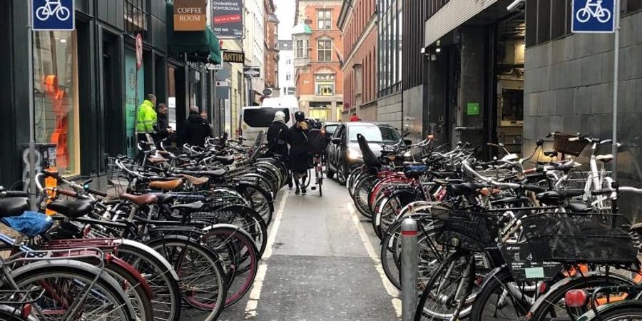 Auch in Kopenhagen gibt es noch ganz klassische Parkhäuser für Autos - direkt daneben ein Fahrradparkplatz. Foto: Steffen Trumpf/dpa