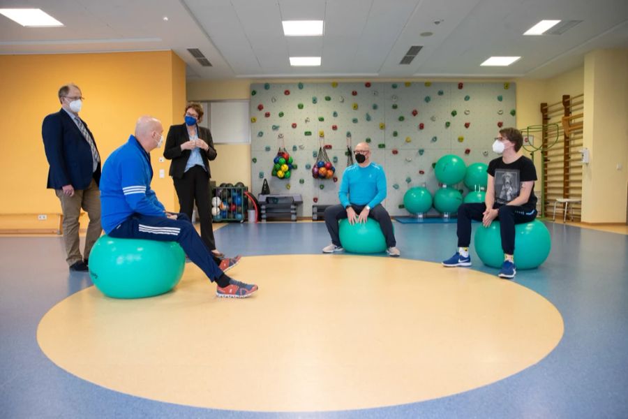 21.01.2022, Niedersachsen, Bad Rothenfelde: Die Long-Covid-Patienten Jörg Schneider (2.v.r.) und Ulrich Lowers (r) sitzen beim Atemtraining mit Physiotherapeut Mirko Weernink (2.v.l.) in ein