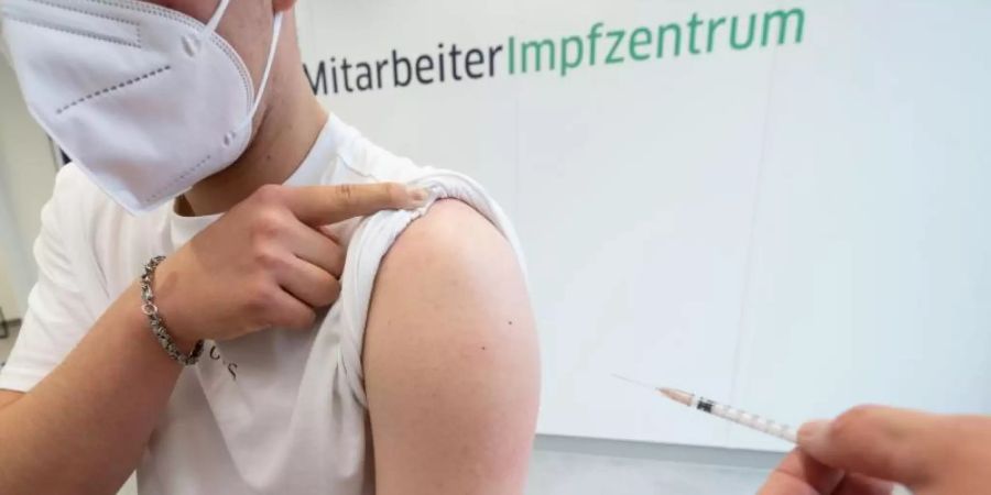 Ein Mann wird mit dem Corona-Impfstoff von Biontech/Pfizer geimpft. Im sechsten Monat nach dem Start der Corona-Impfkampagne in Deutschland hat beinahe die Hälfte der Bevölkerung mindestens eine erste Dosis erhalten. D. Foto: Marijan Murat/dpa