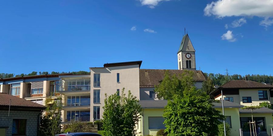 Dorfbild in Eschenbach (SG): Pension Mürtschen mit der Kirche daneben.