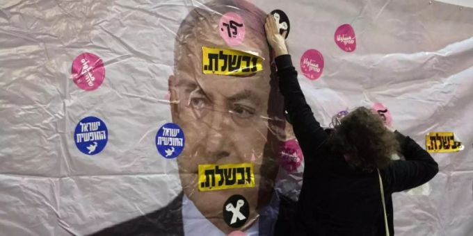 Ein Plakat mit dem Konterfei von Israels Premierminister Netanjahu wird mit Aufklebern überklebt. Foto: Sebastian Scheiner/AP/dpa Ein Plakat mit dem Konterfei von Israels Premierminister Netanjahu wird mit Aufklebern überklebt. Foto: Sebastian Scheiner/AP/dpa