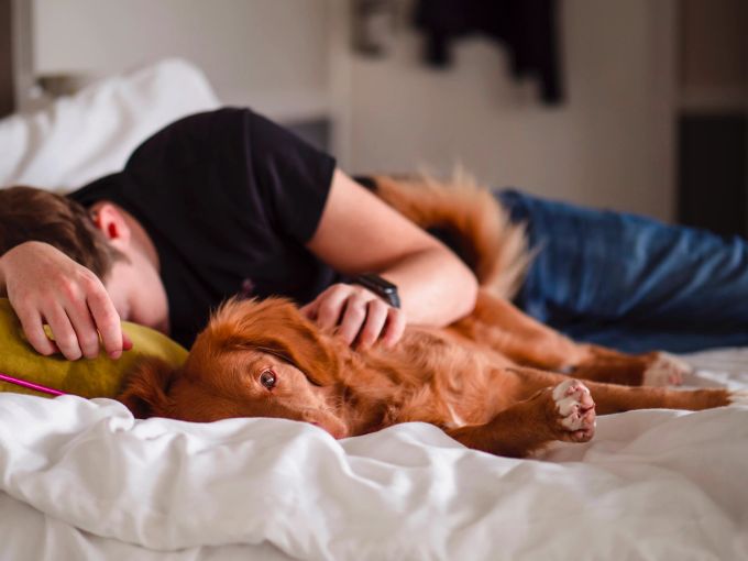 Die Symptome von Long Covid sind diffus. Mann mit Hund